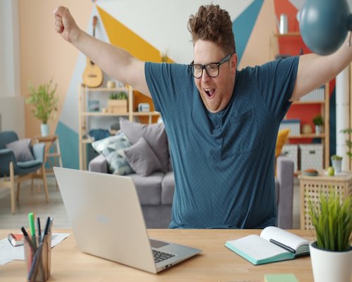 A person stretching their arms while sitting at a desk in a home office